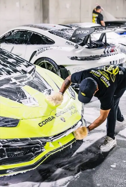 Nico hand-washing a neon Porsche in Corsa Esclusiva livery