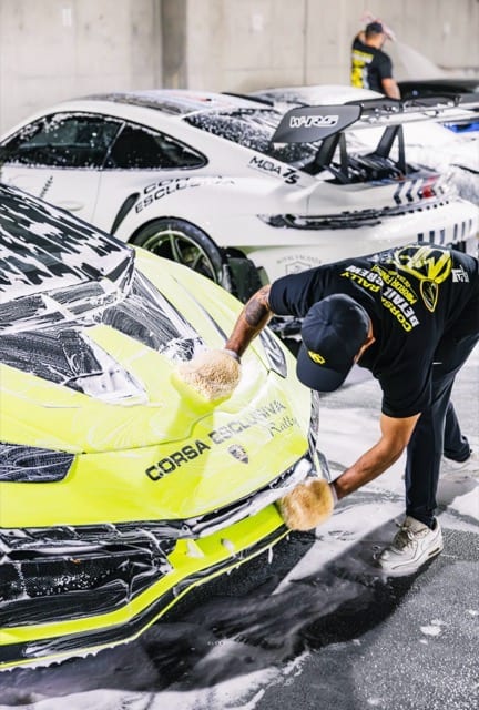 Nico hand-washing a neon Porsche in Corsa Esclusiva livery